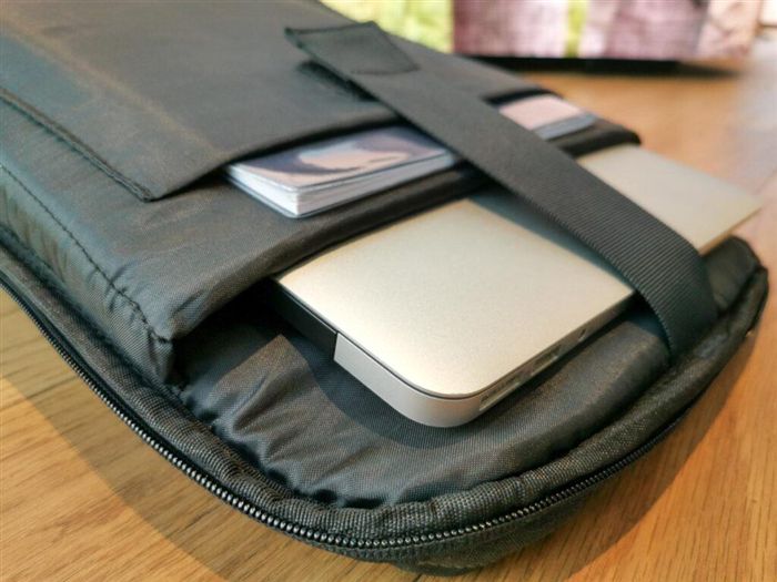 Фотография открытого рюкзака, на котором виден чехол для переноски ноутбука. из