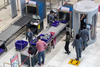 Путешественники выносят багаж на контрольно-пропускных пунктах аэропорта