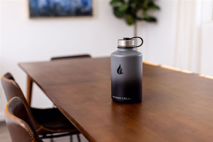 На столе стоит бутылка для воды из нержавеющей стали Hydro Cell.